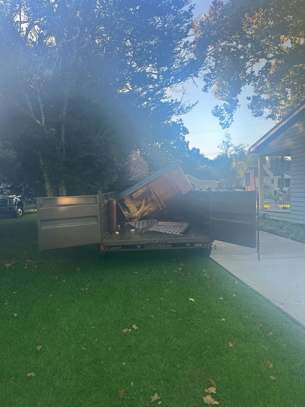 Open dump trailer and pickup at a residential property