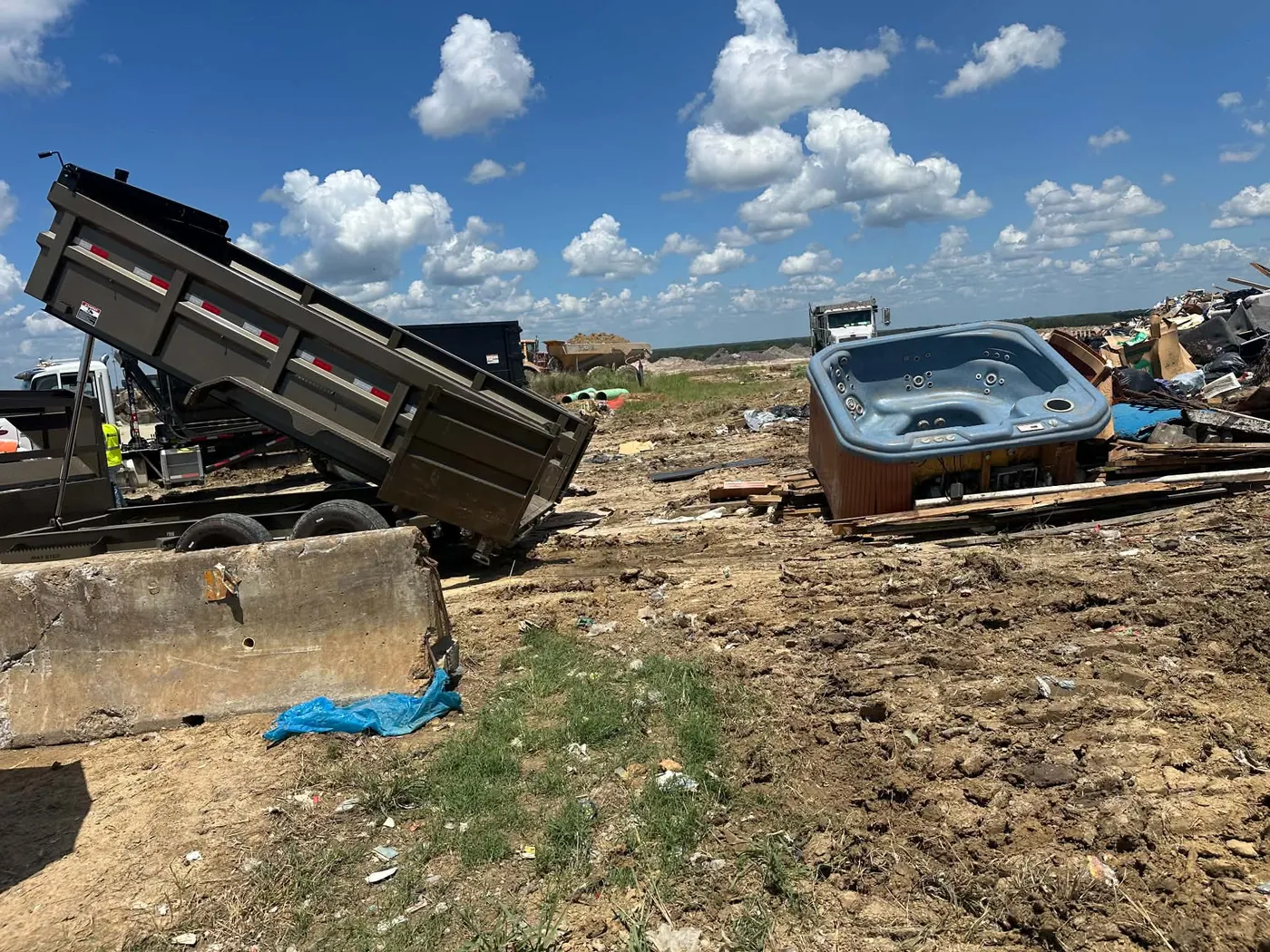 Dump trailer with bulky discarded items in an open work area