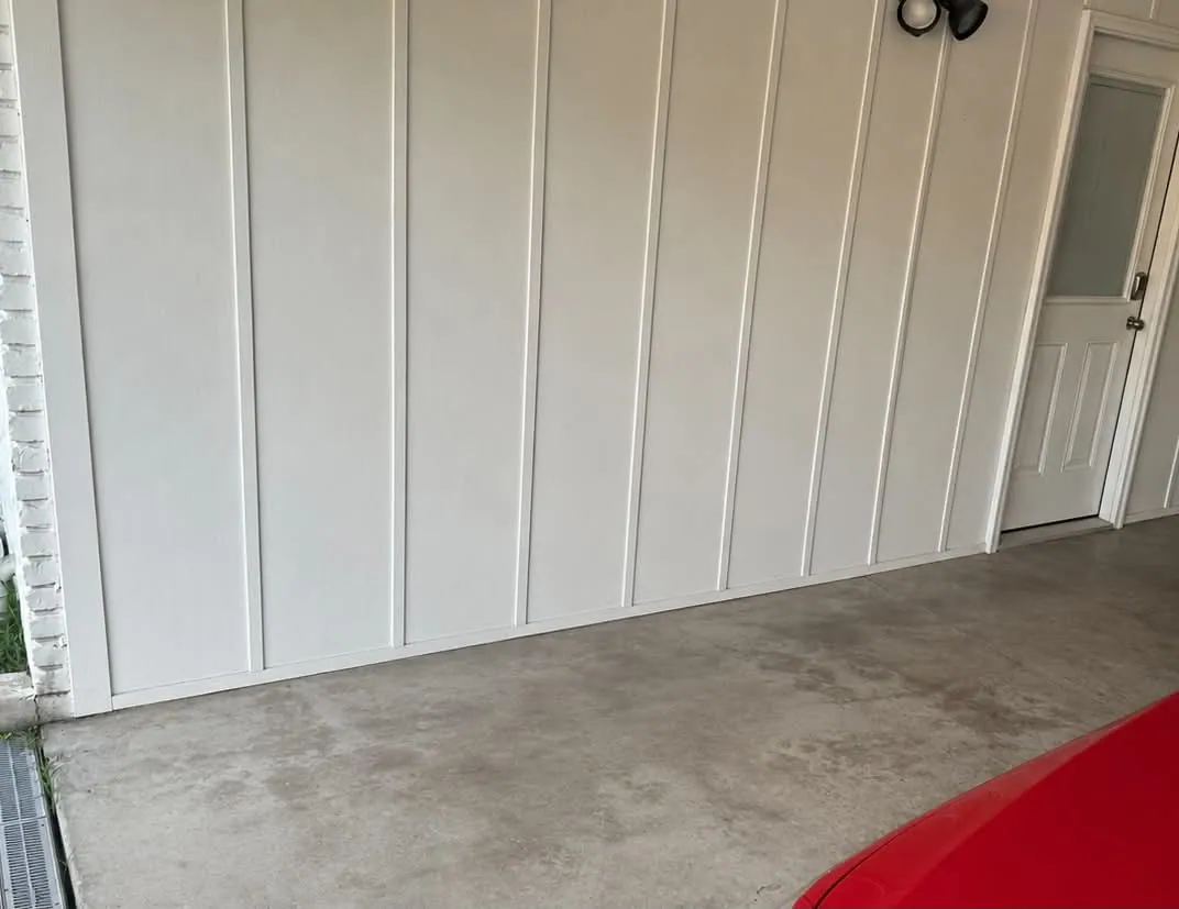 Residential garage with an open floor area and the edge of a red vehicle