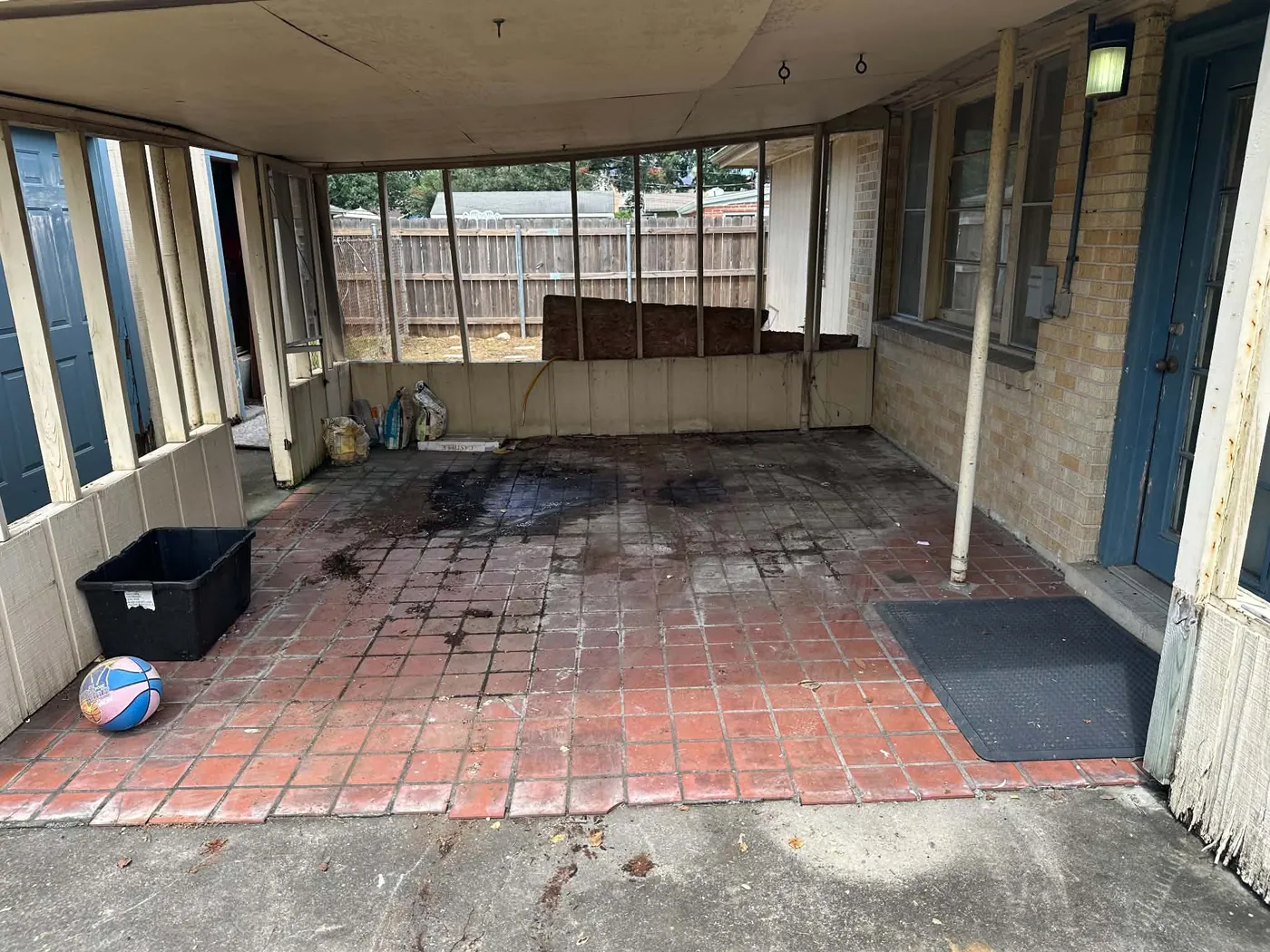 Screened porch with open tiled floor and a small bin and ball